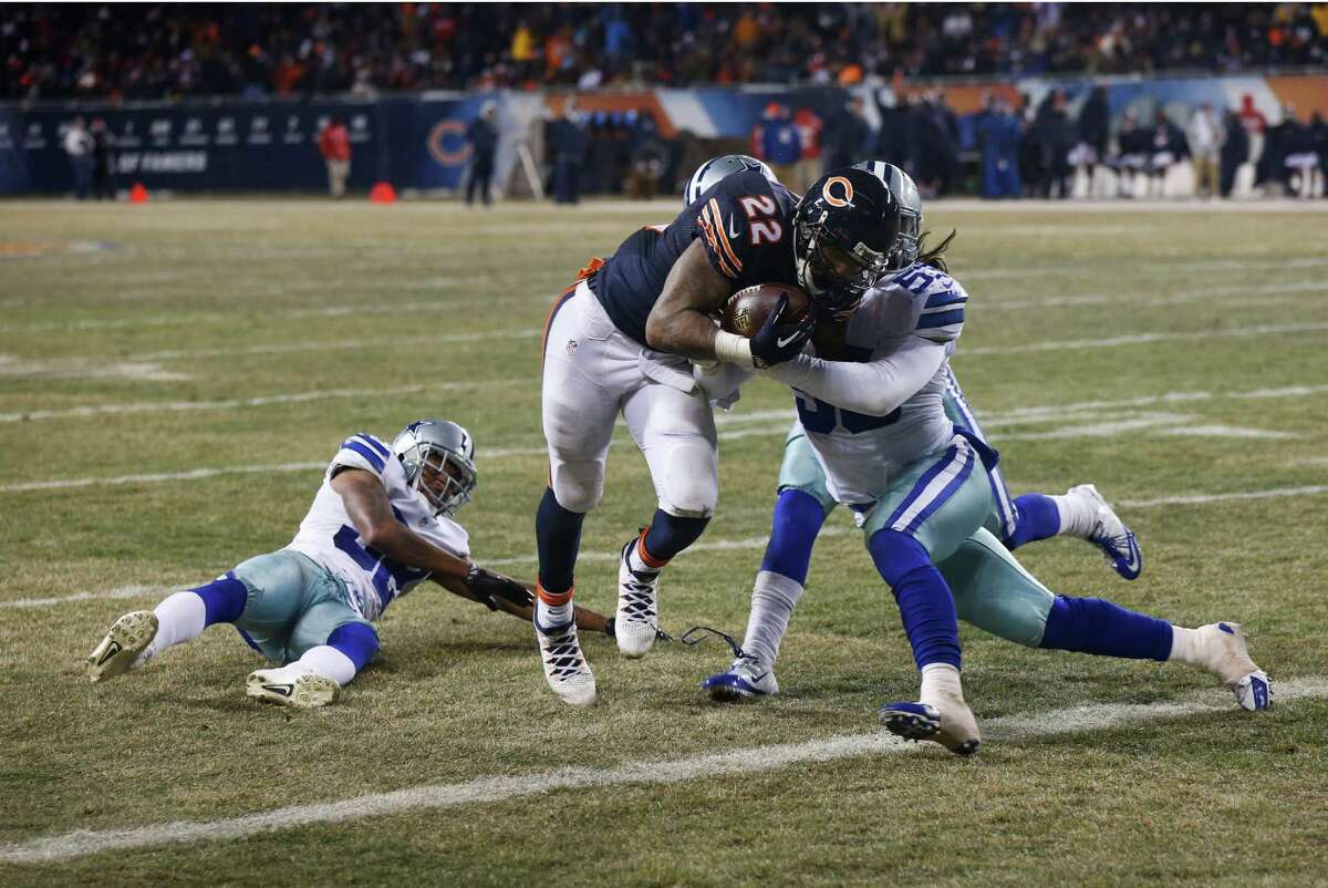 Dallas Cowboys outside linebacker Cameron Lawrence (53) tries to tackle Chicago Bears running back Matt Forte (22) as Forte makes a touchdown run during the second half of an NFL football game, Monday, Dec. 9, 2013, in Chicago. (AP Photo/Charles Rex Arbogast)