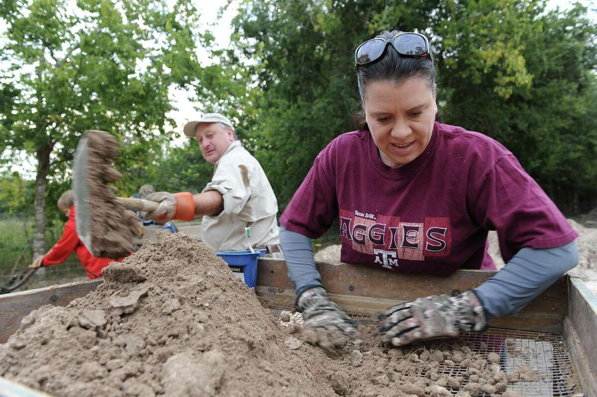 Bob Sewell shovels sand while Kathleen Hughes shifts through it to find artifacts at a location in Cypress. Both are members of the Houston Archeological Society and volunteered to search for artifacts in soil excavated from a Grand Parkway construction site.