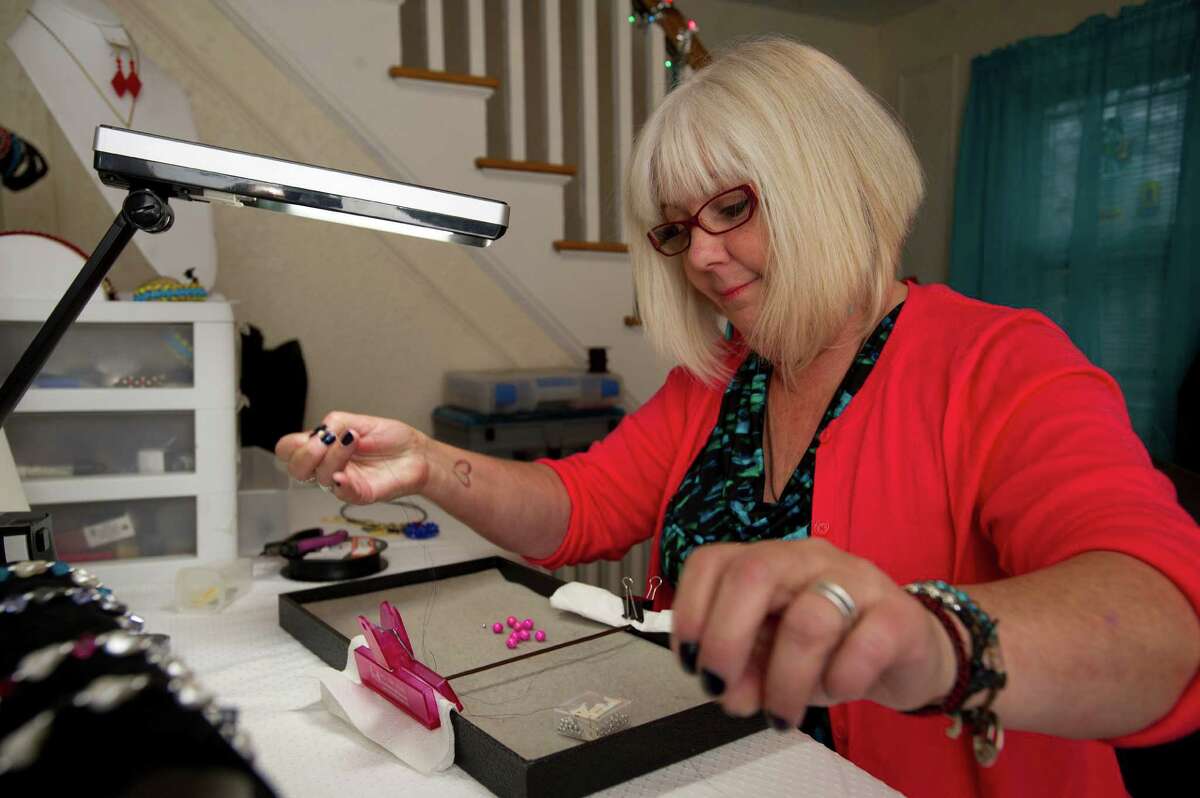 Sandy D'Andrea makes jewelry for Jewels for Hope, the company she owns with her daughter, Stevie, on Friday, December 6, 2013.