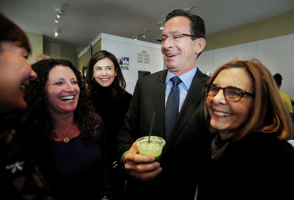 Governor Dannel P. Malloy samples a juice drink with Tara Cook-Littman, second from left, after a ceremonial bill signing of Public Act 13-183, that requires the labeling of genetically engineered foods, at Catch a Healthy Habit Cafe at 39 Unquowa Road in Fairfield, Conn. on Wednesday, December 12, 2013. Cook-Littman, of GMO Free CT, has been the driving force championing the GMO labeling law in the legislature.