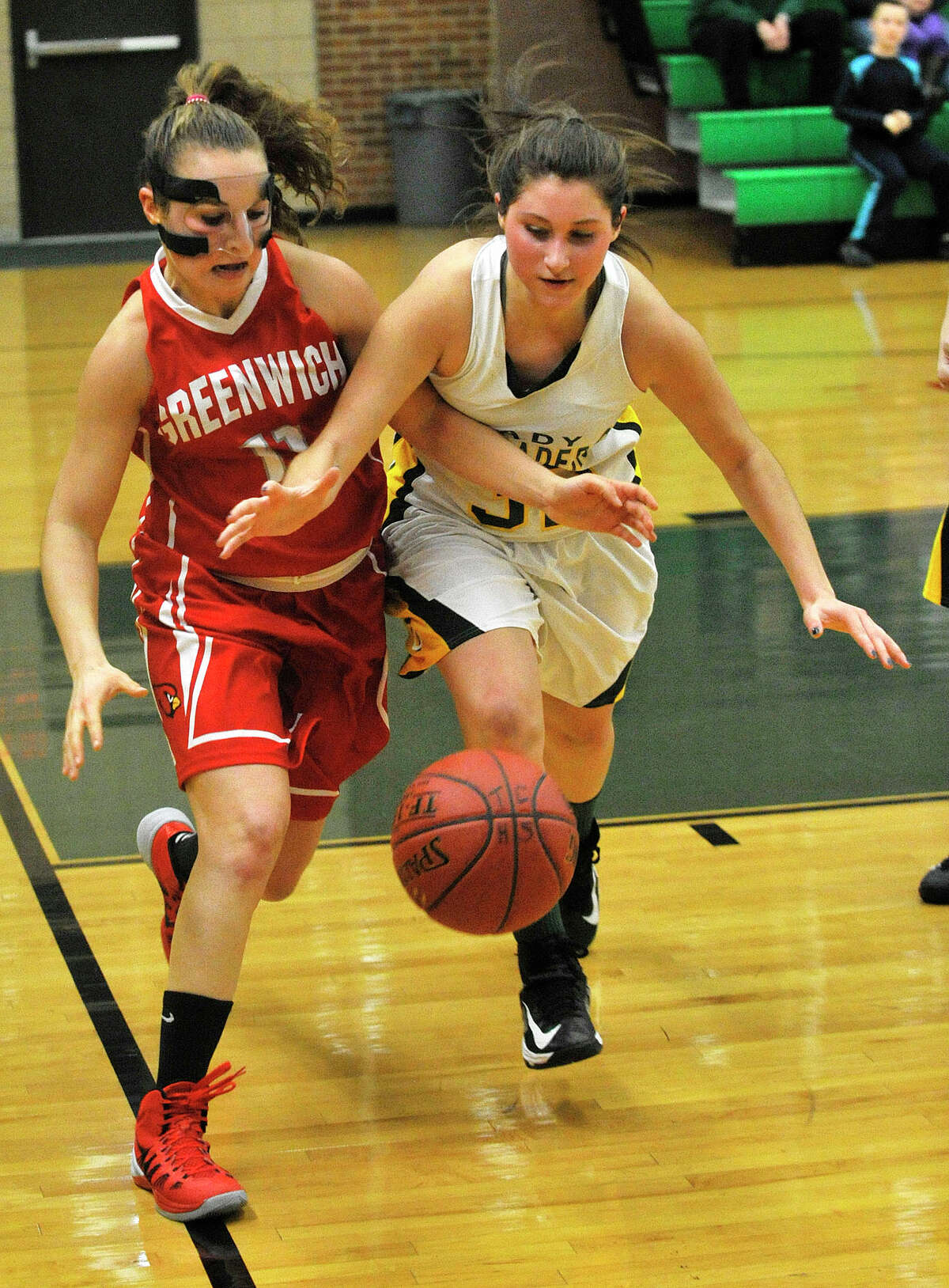 Greenwich's Alexa Moses and Trinity Catholic's Gina DeVito compete for the loose ball during their game at Trinity Catholic High School in Stamford, Conn., on Wednesday, Dec. 11, 2013. Greenwich won, 68-32.