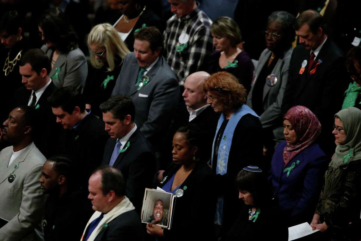 Family members of victims of gun violence stand as they hold a vigil for victims of the shooting at Sandy Hook Elementary School in Newtown, Conn. and other victims of gun violence, Thursday, Dec. 12, 2013, at the National Vigil for Victims of Gun Violence at the National Cathedral in Washington. The one year anniversary of the Newtown, Conn. shootings is December 14.