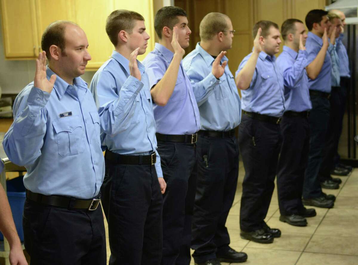 New members of the Danbury Fire Department are sworn in at the induction ceremony at the Danbury Fire Department Headquarters in Danbury, Conn. on Thursday, Dec. 12, 2013. This year's ceremony inducted a large class of 14 new firefighters, the first additions to the fire department since 2007.