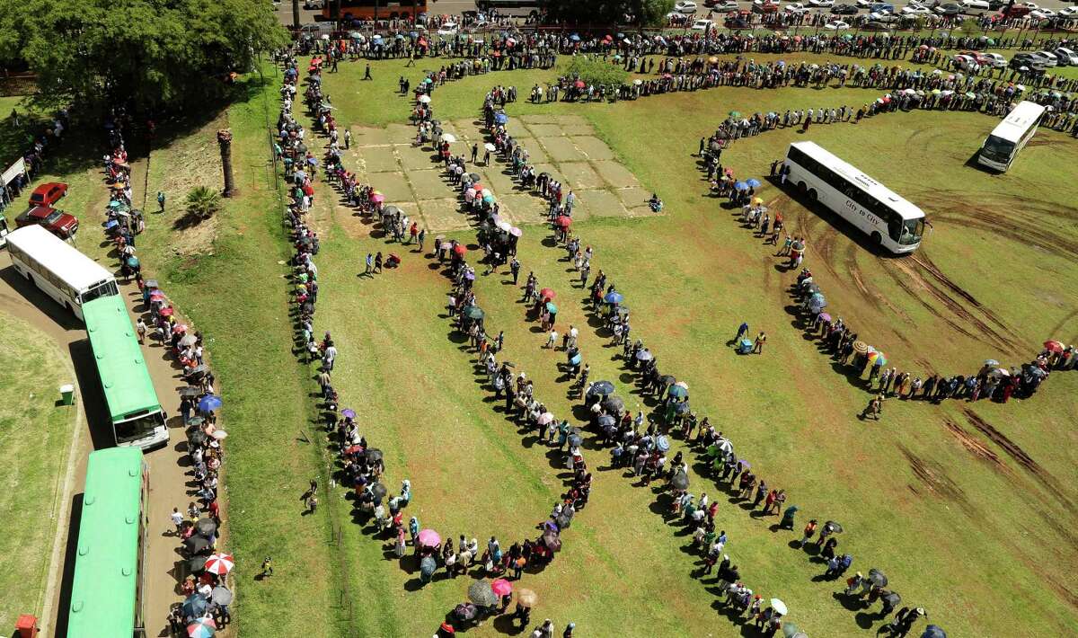 People queue to catch a bus to see the remains of Nelson Mandela at the Union Buildings in Pretoria, South Africa, on Thursday. Viewing will end Friday and the body will be transported to his home village, with burial on Sunday.
