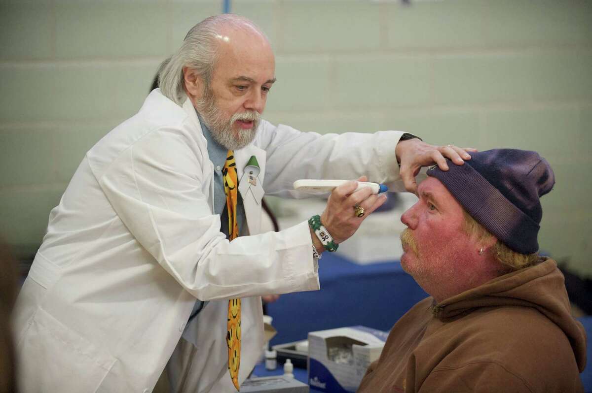 Dr Joseph Young, of Newtown, performs a tonometry test, to check for glaucoma, on William Melvin, of Danbury, during the 7th annual Project Homeless Connect in the Bill Williams Gymnasium at Western Connecticut State University on Friday, December 13, 2013. Melvin results were good. Dr Young has a practice in Newtown.