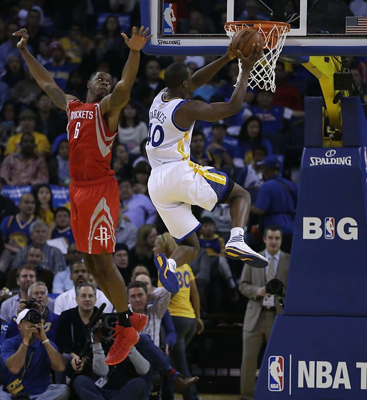 Golden State Warriors' Harrison Barnes, right, drives past Houston Rockets' Terrence Jones (6) during the first half of an NBA basketball game Friday, Dec. 13, 2013, in Oakland, Calif. (AP Photo/Ben Margot)