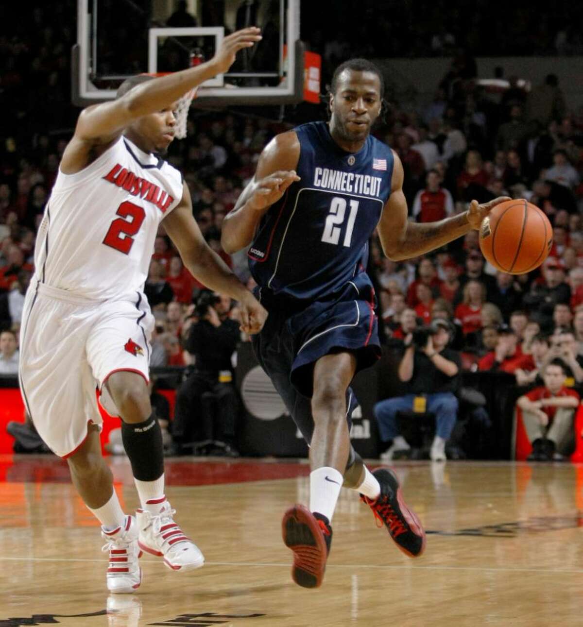 Connecticut's Stanley Robinson drives past Louisville's Preston Knowles during the first half of an NCAA college basketball game in Louisville, Ky., Monday, Feb. 1, 2010. (AP Photo/Ed Reinke)