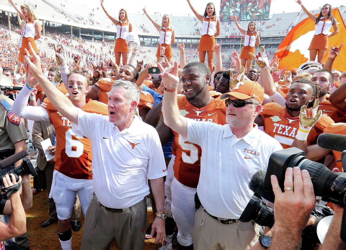 Texas Longhorns' Case McCoy (left), head coach Mack Brown (center) and others celebrate after the Red River Rivalry against the Oklahoma Sooners Saturday Oct. 12, 2013 at Cotton Bowl Stadium in Dallas, Tx. The Longhorns won 36-20.
