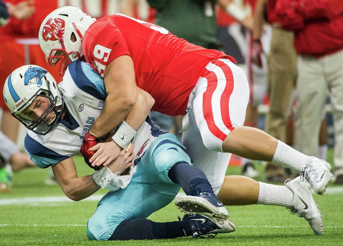 Johnson quarterback Hunter Rittimann (12) is sacked by Katy defensive lineman Jesse Brown (99) during the first half of a Class 5A state semifinal high school football playoff game at Reliant Stadium on Saturday, Dec. 14, 2013, in Houston.