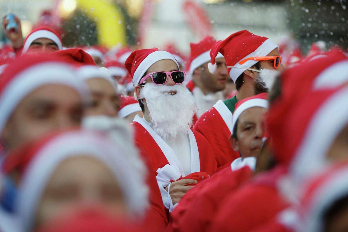 Participants wait for the start of the Santa Claus or 'Papa Noel' race on December 14, 2013 in Madrid, Spain. An estimated 6,000 adults dressed as Santa Claus and children dressed as elves turned out to take part in the 5.5 kilometer race to kick off Madrid's Christmas festivities. One Euro per participant will be donated to a charity that distributes presents to deprived children around the world by the event's organizers.