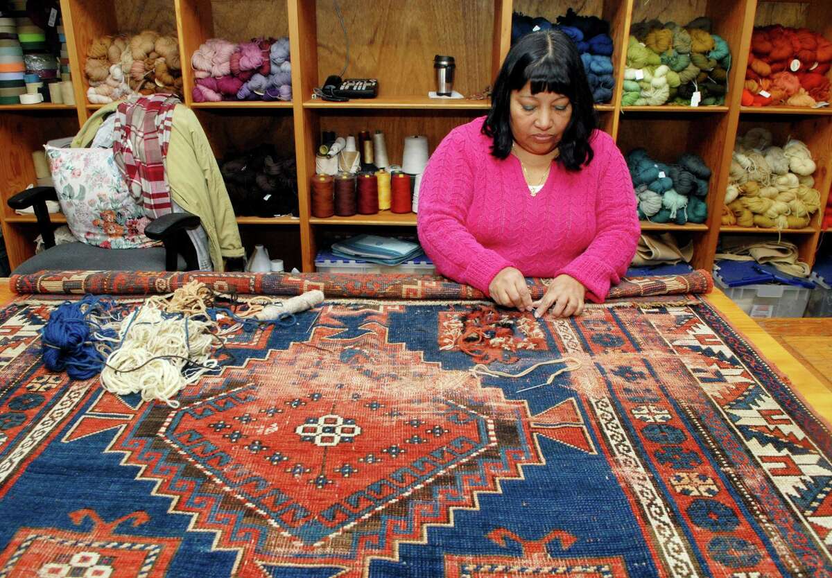 Olga Mendez works on repairing a oriental rug at Triple S carpet cleaners in Stamford, Conn. on Monday December 2, 2013.