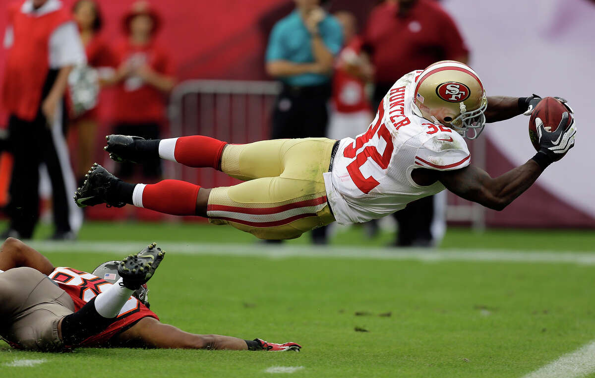 San Francisco 49ers' Kendall Hunter (32) dives into the end zone to score after picking up a fumble by Tampa Bay Buccaneers' Russell Shepard during the fourth quarter of an NFL football game Sunday, Dec. 15, 2013, in Tampa, Fla.