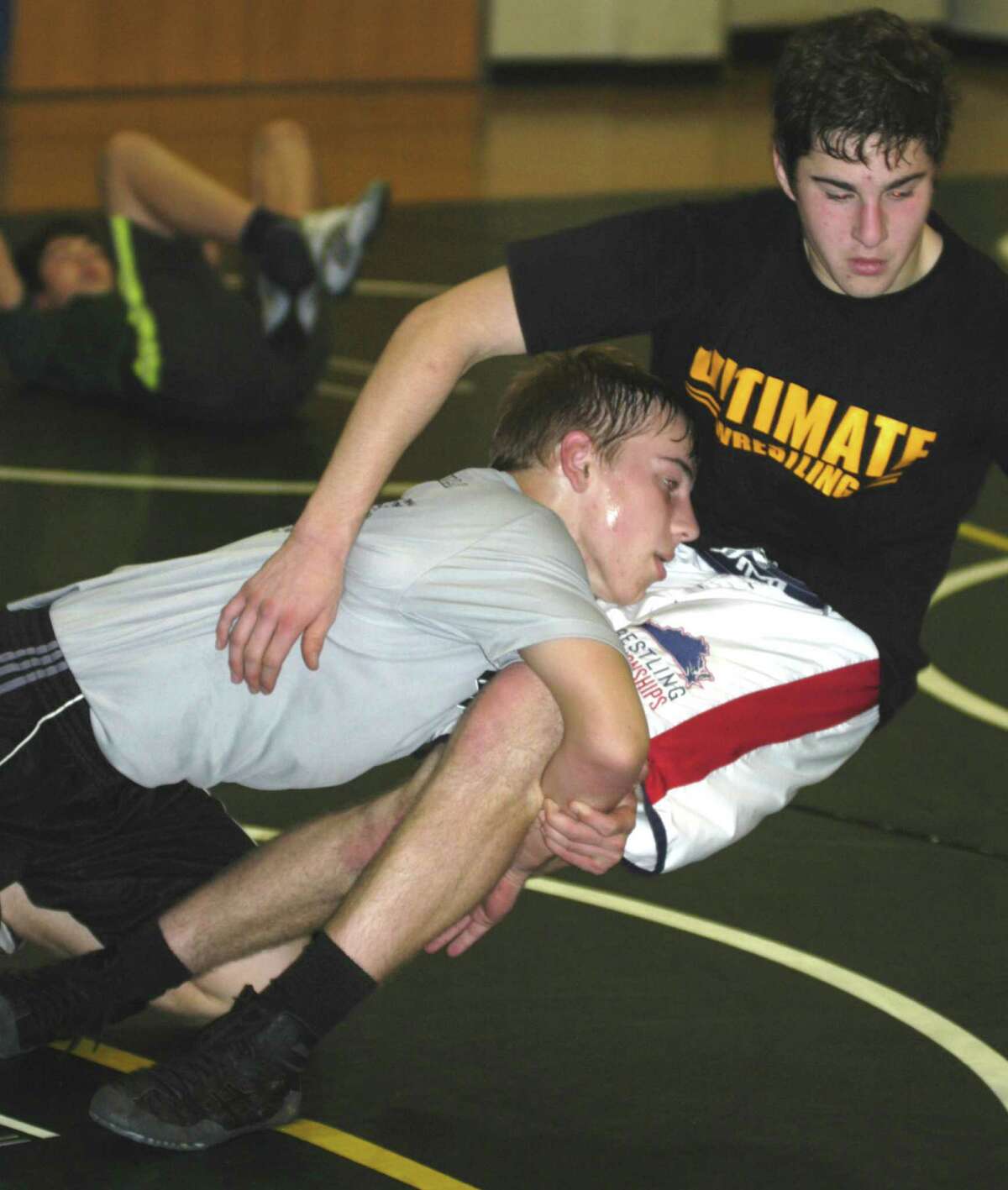 Green Wave athletes Zach Arnold, left, and Brett Leonard work out Dec. 5 during New Milford High School wrestling practice at NMHS. Dec. 5, 2013
