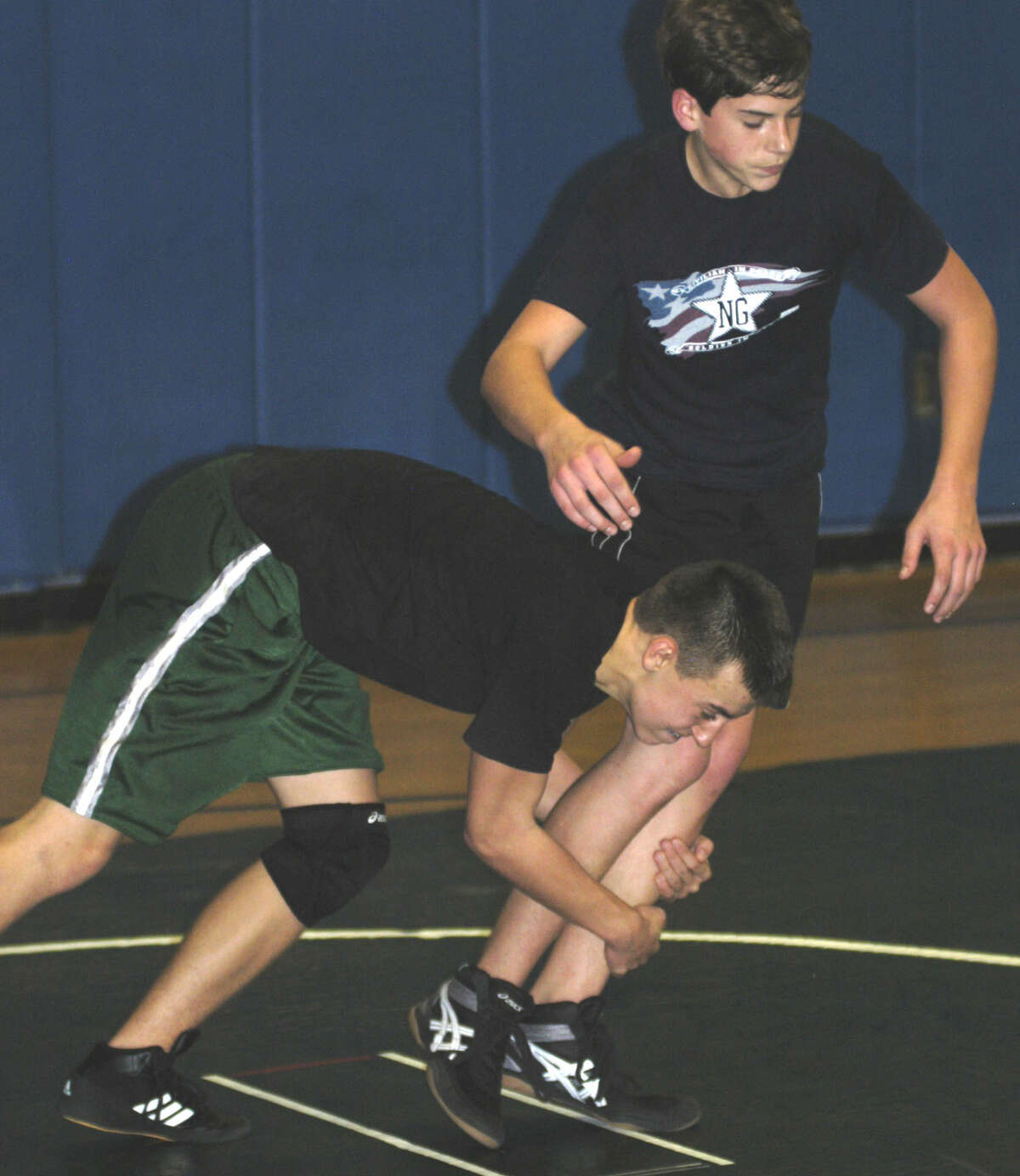 The Green Wave's David Ireland, left, takes down fellow freshman Jordan Hill during New Milford High School wrestling practice at NMHS. Dec. 5, 2013