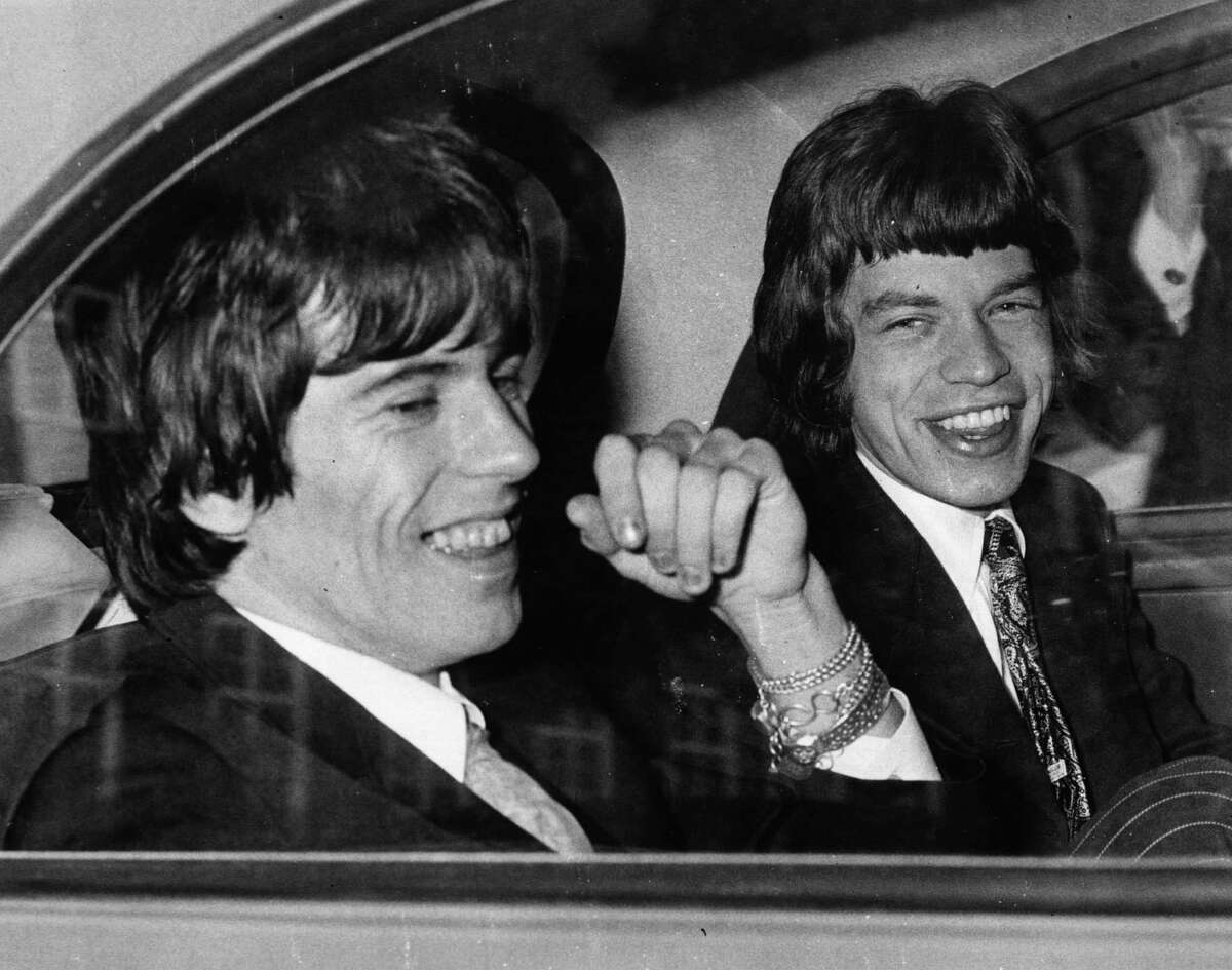 10th May 1967: Rolling Stones songwriters, guitarist Keith Richards, left, and singer Mick Jagger share a joke in the back of a car as they leave Chichester Magistrates Court where they appeared on drug summonses.