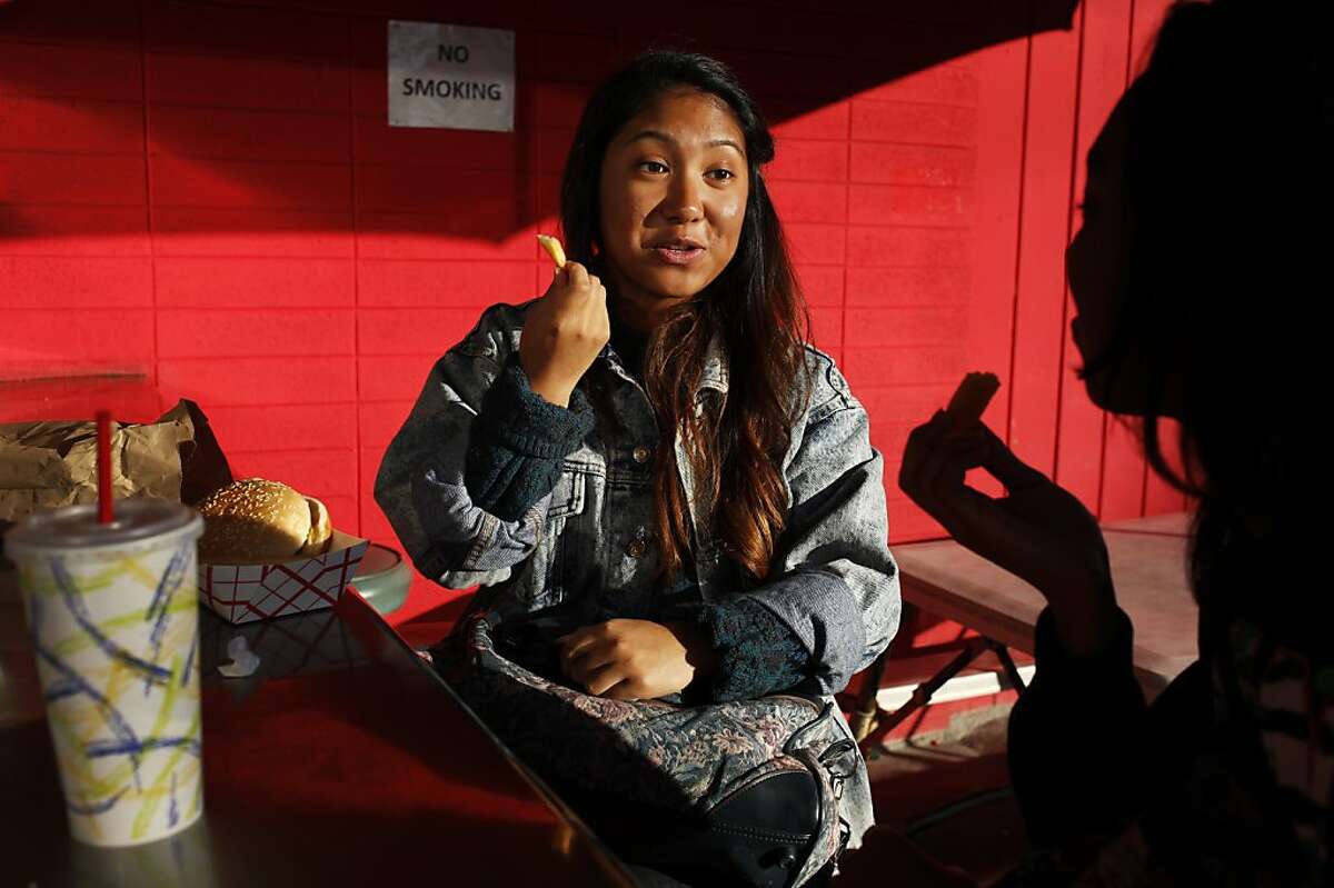 Joy Abad, 16, enjoys a burger and fries with her friend Shayla Richardson, right, also 16, on December 11, 2013 at Beep's Burgers in San Francisco, Calif. Although both women live in the neighborhood, it was Abad's first time at the restaurant, which was recommended by Richardson.