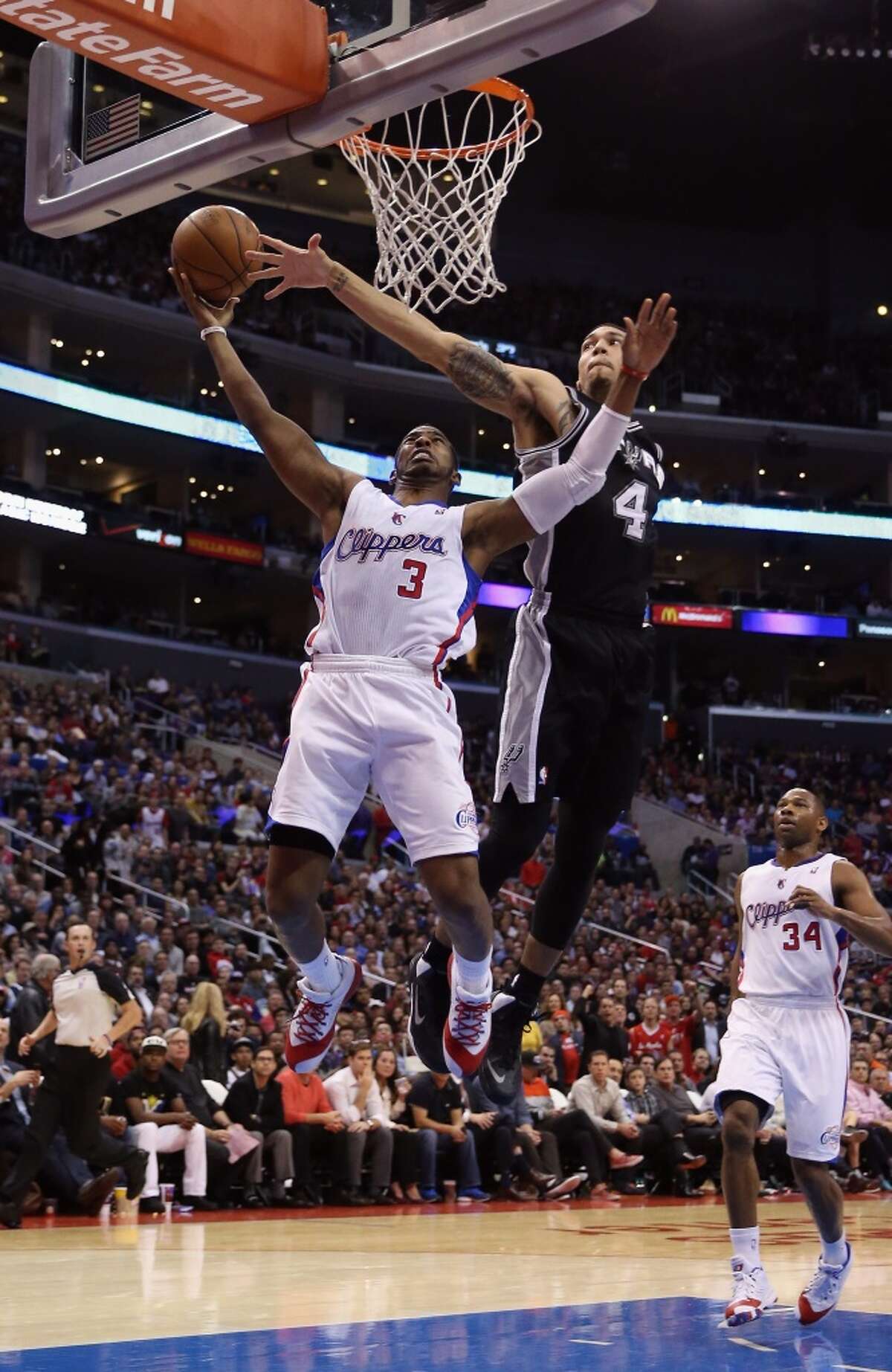 Chris Paul #3 of the Los Angeles Clippers drives past Danny Green #4 of the San Antonio Spurs for a lay up in the first half at Staples Center on December 16, 2013 in Los Angeles, California.