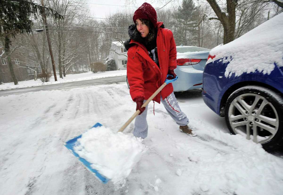 Lisa Michie clears her driveway of snow in Stamford, Conn., on Tuesday, Dec. 17, 2013.