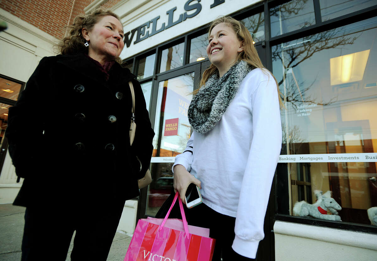 Joyce Kirchgasser and her daughter Katie, 15, of Fairfield, discuss holiday shopping on the Post Road in downtown Fairfield, Conn. on Monday, December 16, 2013.