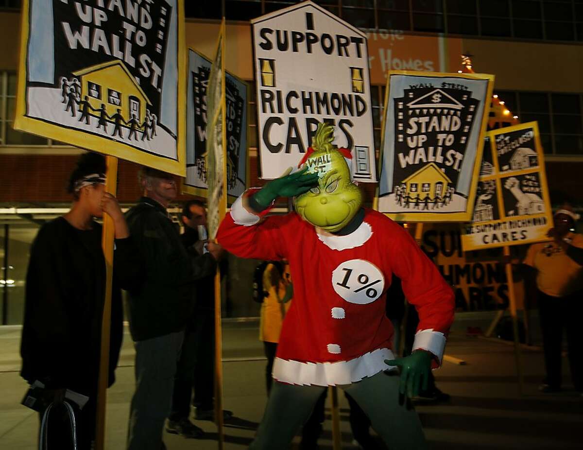 In a skit performed at the rally, the Grinch tried to steal peoples homes Tuesday December 17, 2013 in Richmond, Calif. Supporters of the Richmond, Calif. controversial plan to use eminent domain to seize and restructure underwater mortgages rallied in front of city hall and took their message to a City Council meeting, where they voted on some parameters of the plan.