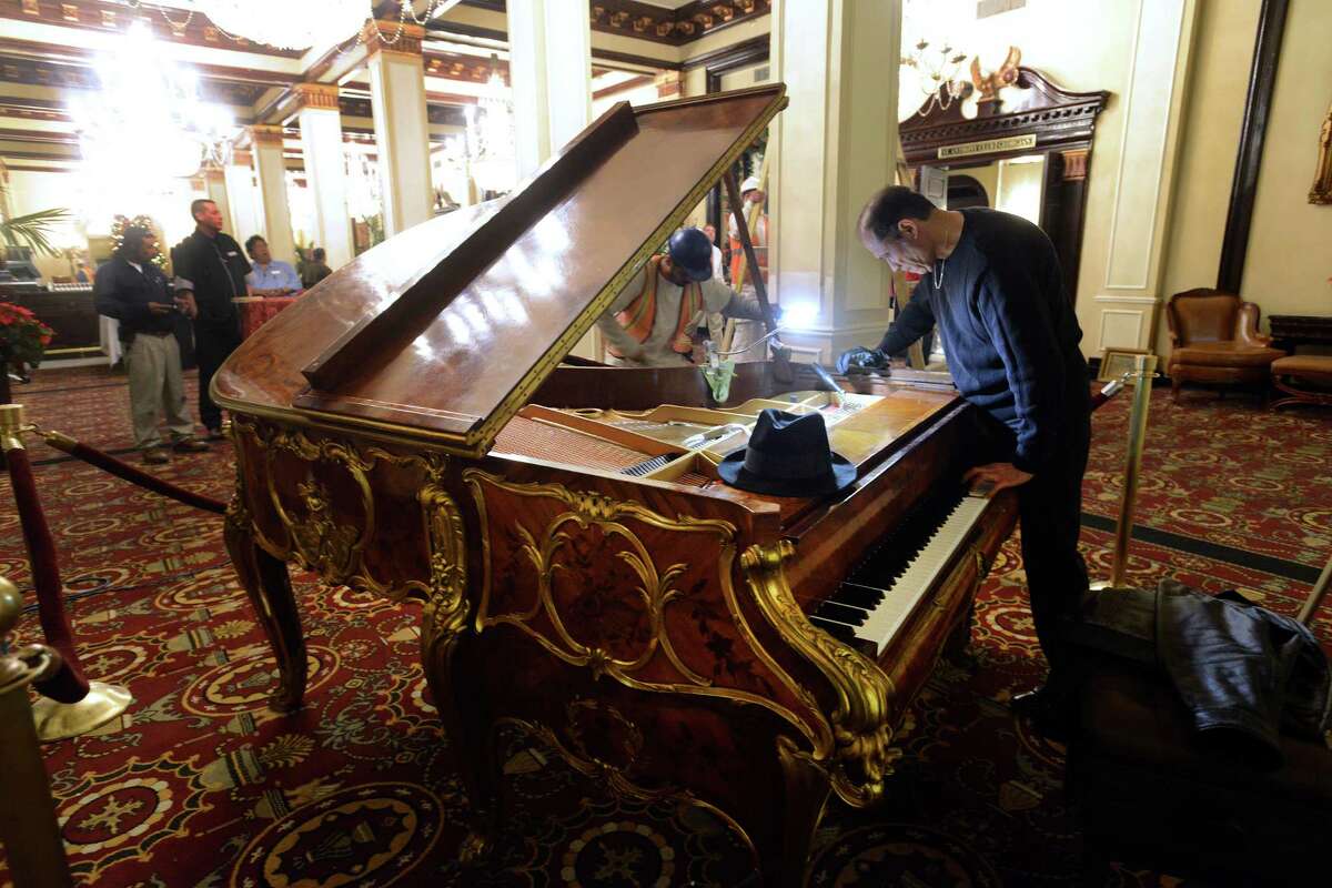 Johnny M. Verduzco, a piano tuner, works on the ornate Steinway piano that has been returned to the St. Anthony Hotel after being gone for 20 years. Ralph W. Morrison, former owner of the hotel, brought the piano to San Antonio in 1938, where it was the musical centerpiece for over 50 years. In March, hotel owners paid $220,000 to purchase it at auction.