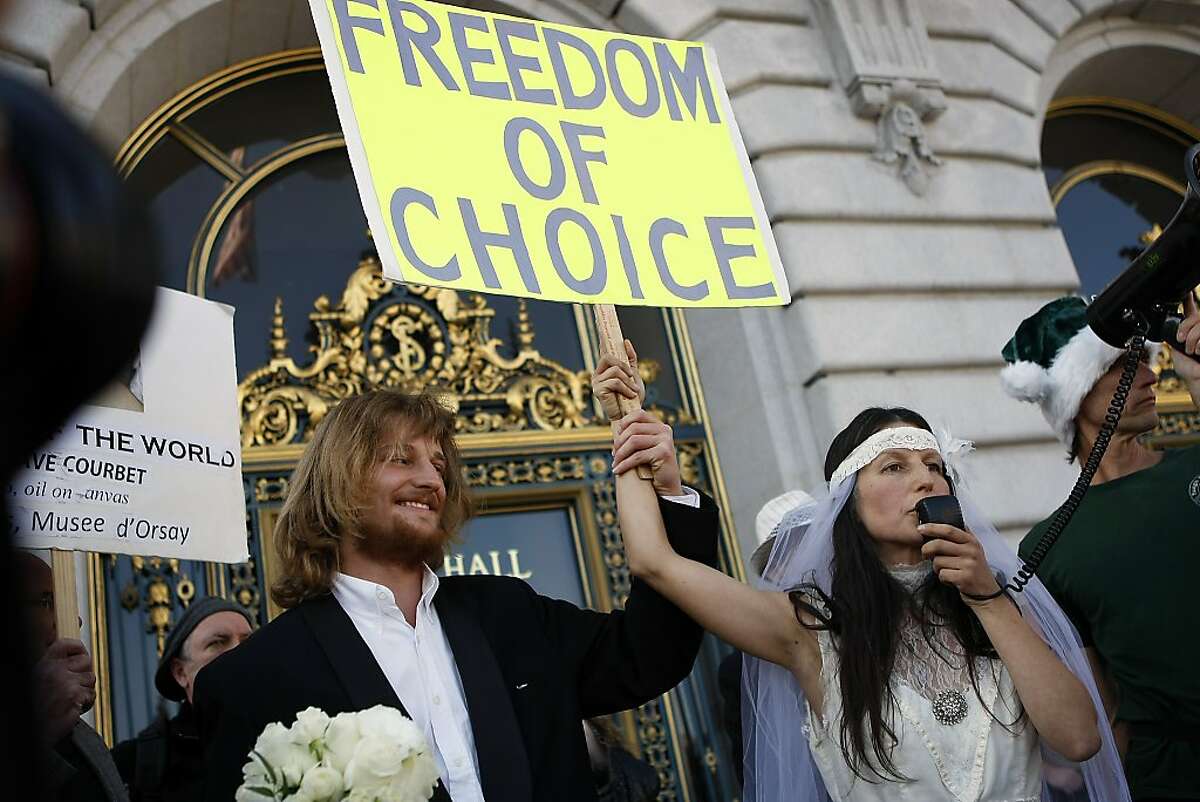 Jaymz Smith and Gypsy Taub hold hands before the start of their naked marriage at City Hall in San Francisco, CA, Thursday, December 19, 2013. Nudity activist Gypsy Taub gets married naked to her fiance Jaymz Smith on the steps of San Francisco City Hall.