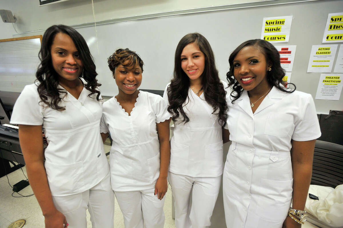 Nursing graduates from left, Judy Gordon, Ashley Lyle, Jessica Kaminski and Joana Lauture pose for a photograph before the Pinning Ceremony for Norwalk Community College nursing students at the college in Norwalk, Conn., on Thursday, Dec. 19, 2013.