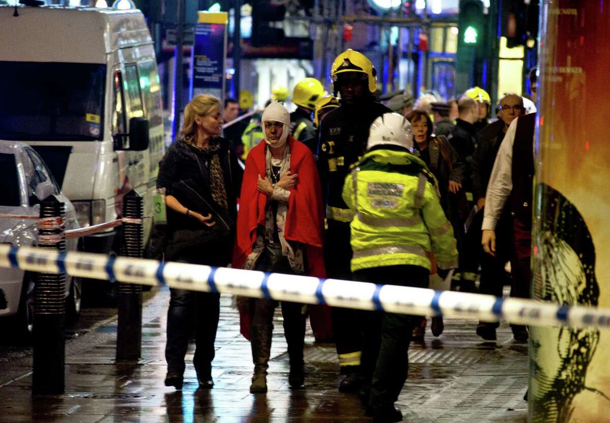 A woman stands bandaged and wearing a blanket given by emergency services following an incident at the Apollo Theatre, in London's Shaftesbury Avenue, Thursday evening, Dec. 19, 2013, during a performance at the height of the Christmas season, with police saying there were "a number" of casualties. It wasn't immediately clear if the roof, ceiling or balcony had collapsed during a performance. Police said they "are aware of a number of casualties," but had no further details. (AP Photo by Joel Ryan, Invision)