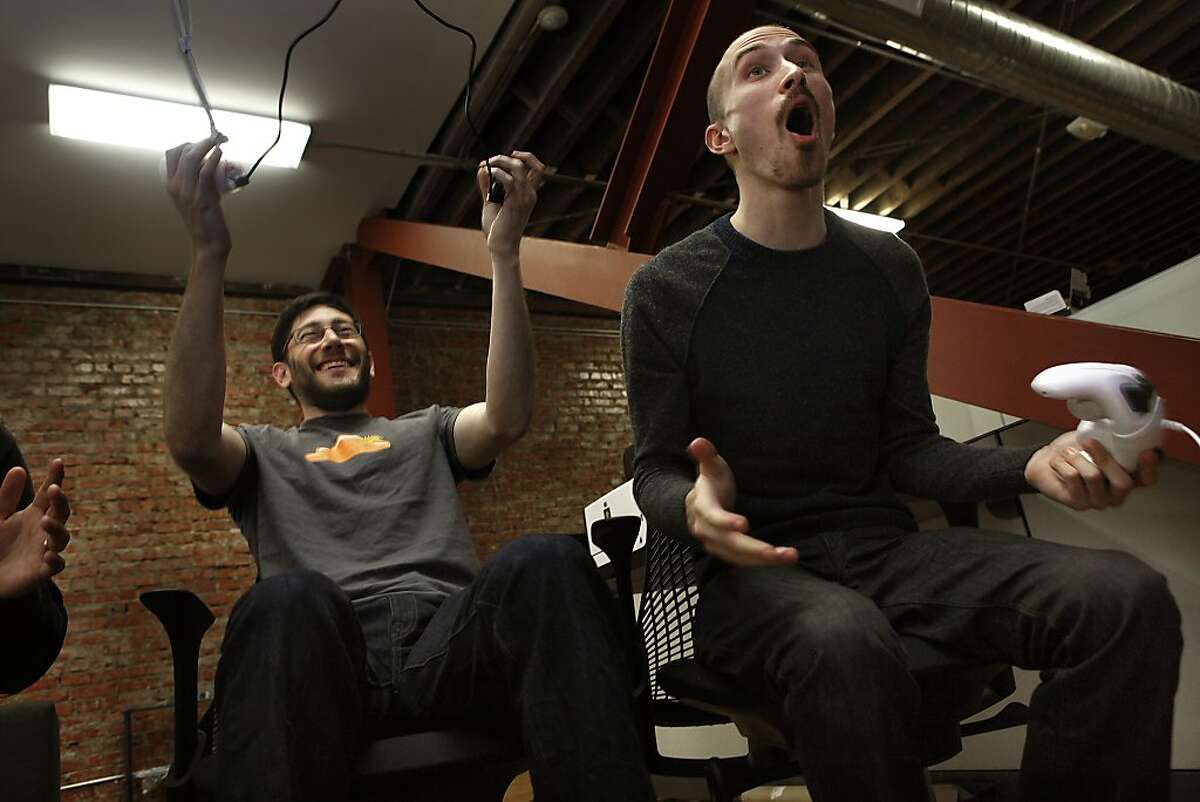 Front end engineer Brian Kassouf (left) plays a video game with chief executive officer Alan Schaaf (right) at the Imgur office in San Francisco, Calif., after lunch on Monday, December 16, 2013.
