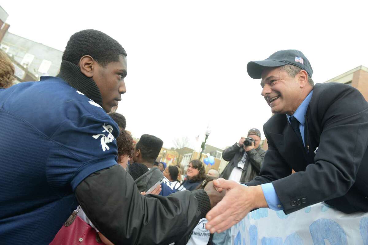 Ansonia High School football player Saiheed Sanders shakes hands with mayor David S. Cassetti Saturday, Dec. 21, 2013 during a parade to honor Class S state football champions, the Ansonia Chargers, and Ansonia Youth cheerleaders, AYC National Championship winners and runners-up Saturday, Dec. 21, 2013.