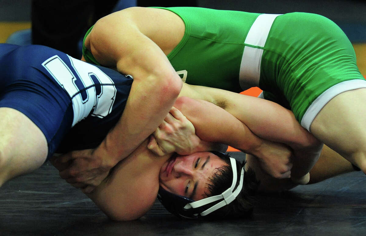 Staples Charles Lomanto tries to avoid a pin by Enfield's Bryan Murphy, during wrestling action in Fairfield, Conn. on Saturday December 21, 2013.