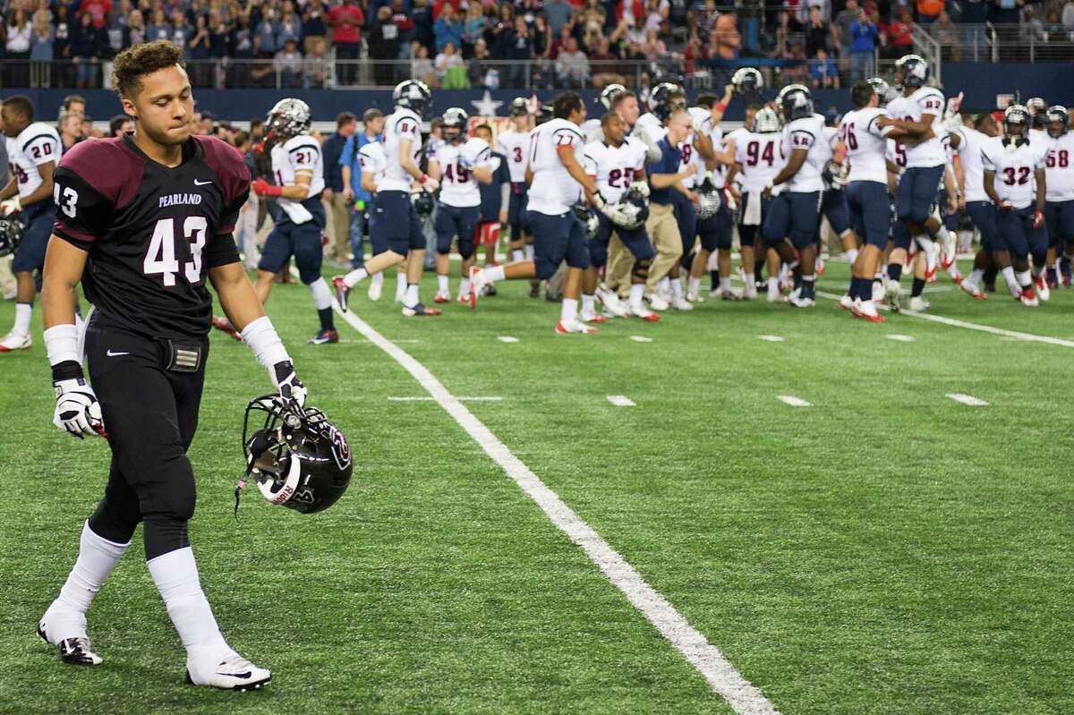 Pearland linebacker Andrew Milburn's expression says it all as he walks off the field while Allen players celebrate their victory in the Class 5A Division I state championship game Saturday.
