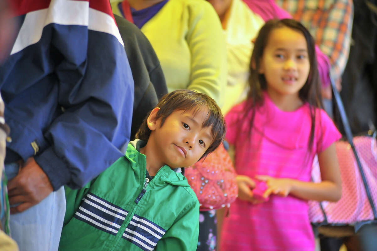 Moung Pu (left) and Nita Tamand look for Santa while waiting in line durinf a toy drive sponsored by the Bexar County Young Tejano Democrats/Brown Berets at the House of Prayer Lutheran Church Sunday, Dec. 22, 2013.