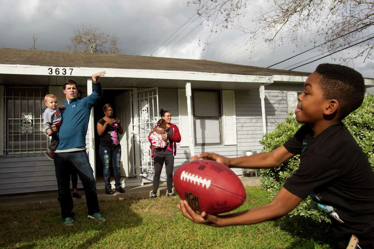 Texans linebacker Brian Cushing plays catch with Darius Montgomery last week after Cushing and his wife, Megan, surprised Darius and his mother, Evelyn Smith, back left, with a houseful of Christmas gifts.