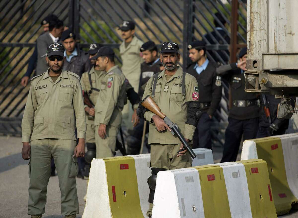 Pakistani para-military troops and police officers stand alert outside the court in Islamabad, Pakistan, Tuesday, Dec. 24, 2013. A bomb scare Tuesday delayed the first hearing in a high treason case against former Pakistani leader Pervez Musharraf, said police and legal officials. (AP Photo/B.K. Bangash)