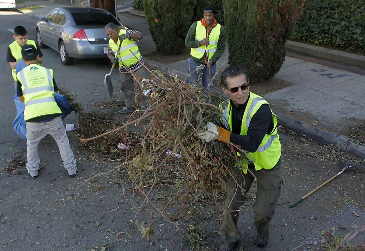 Oakland city council member Noel Gallo (right) and a team of volunteers picks up trash dumped on Champion Street in Oakland, Calif. on Saturday, Dec. 21, 2013. Gallo started the "Safe Clean City" weekly clean-up program at the beginning of the year to control the illegal dumping problem in his district.