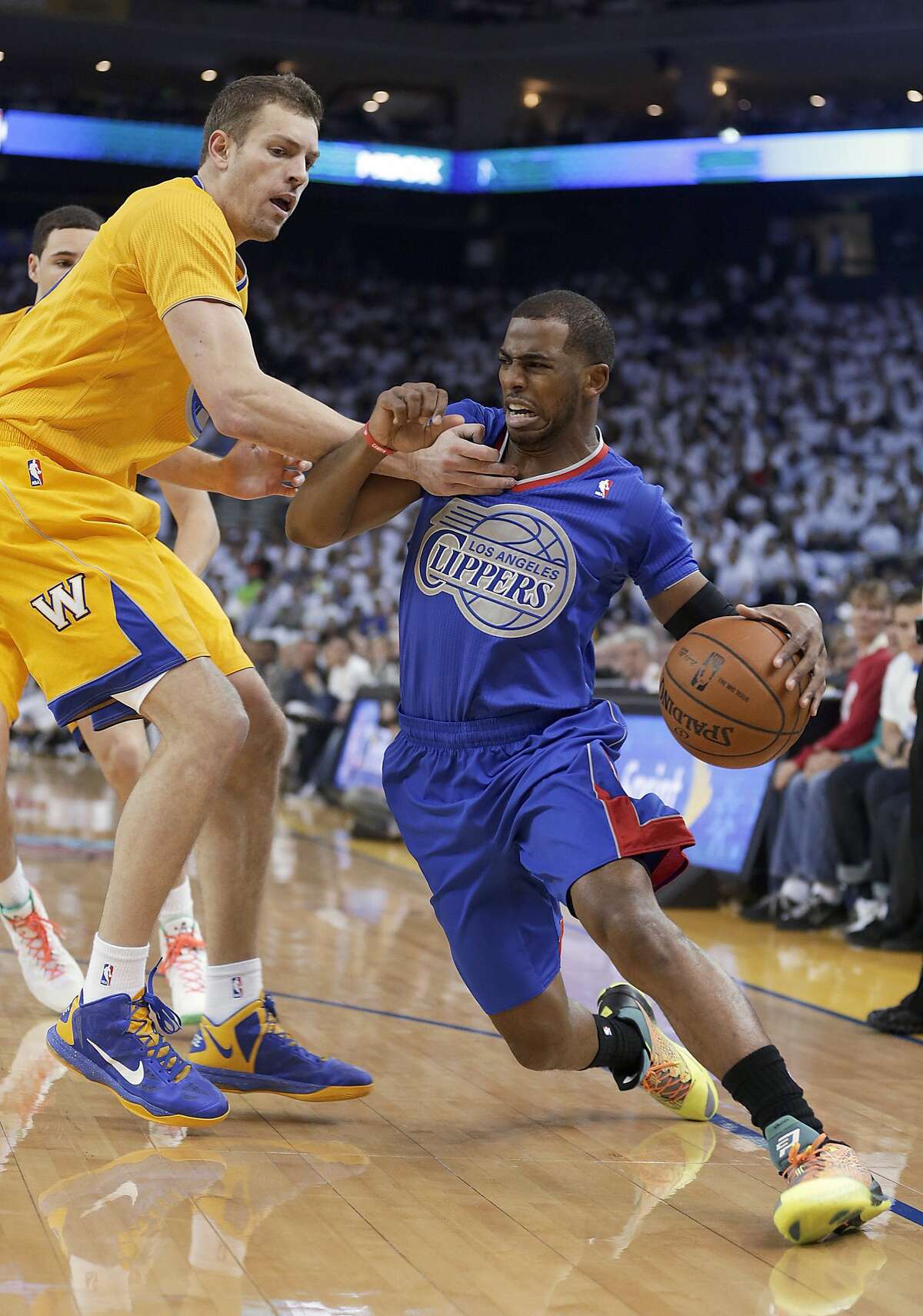 Los Angeles Clippers guard Chris Paul tries to get around Golden State Warriors forward David Lee during the first half of an NBA basketball game, Wednesday, Dec. 25, 2013, in Oakland, Calif. (AP Photo/Tony Avelar)