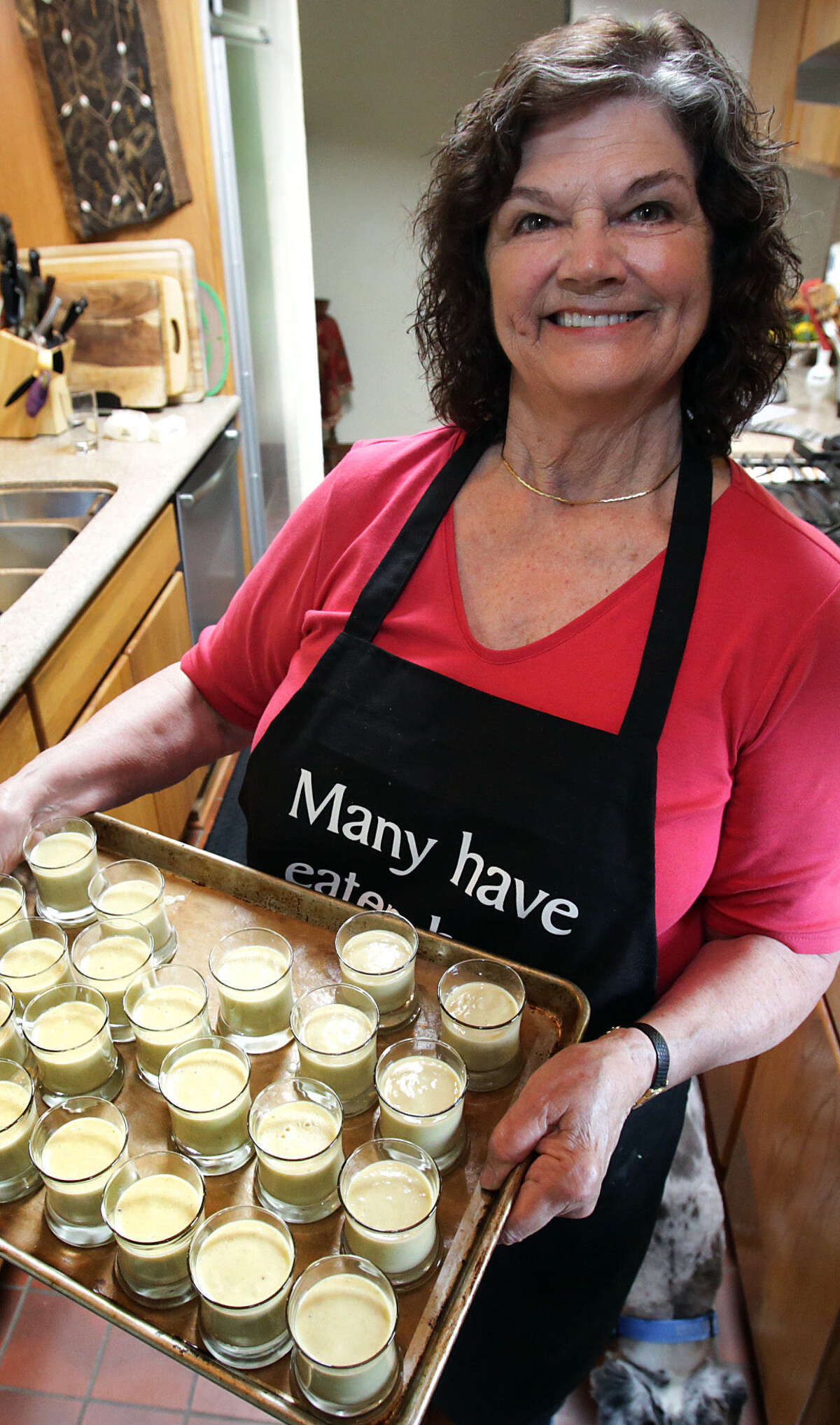 Marianne Anderson prepares individual banana custard desserts in her kitchen.