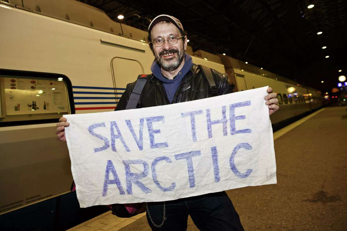 Greenpeace activist Dmitri Litvinov shows a banner reading "Save the Arctic" on arrival at the railway station in Helsinki on December 26, 2013. Dmitri was the first Greenpeace activist on a train out of Russia on December 26, more than three months after he was arrested along with 29 fellow crew members of a ship protesting against Arctic oil drilling. Dmitri Litvinov, a Swedish-American of Russian origin, left Saint Petersburg for Finland's capital Helsinki on a train departing at 8:25 pm (1625 GMT) after Russia issued exit visas for 14 of the crew following a pardon by President Vladimir Putin. AFP PHOTO / LEHTIKUVA / RONI REKOMAA &&& FINLAND OUTRoni Rekomaa/AFP/Getty Images