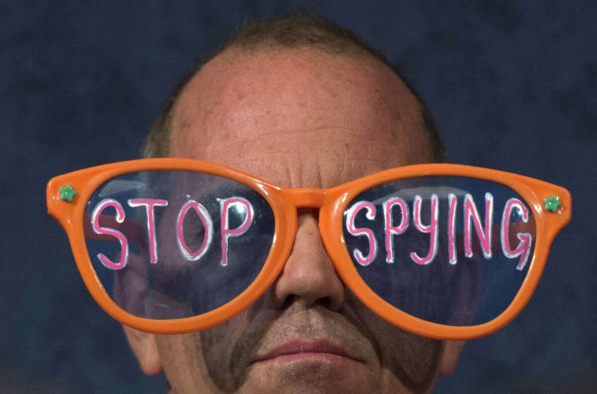 A protester with Code Pink wears giant glasses during a recent House committee hearing with testimony from National Security Agency Director Keith Alexander. Separate federal court rulings are divided on NSA domestic surveillance.