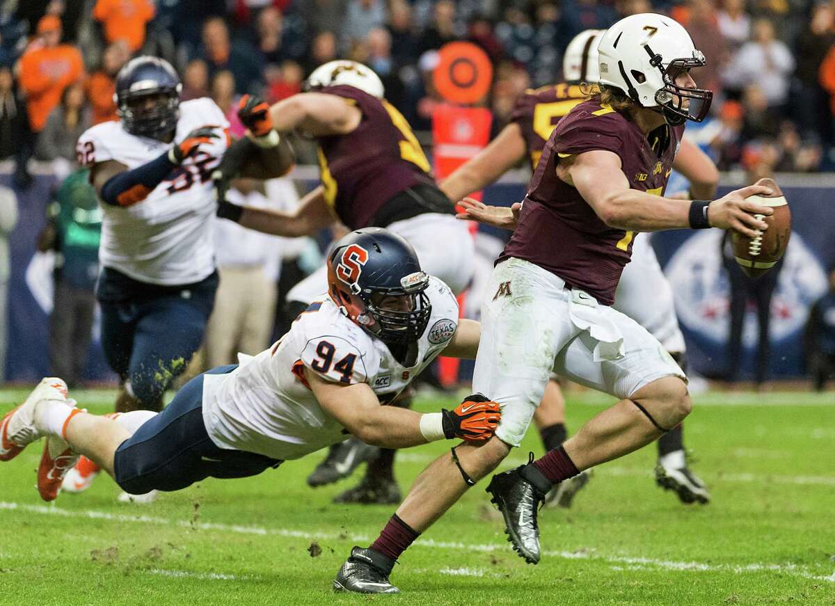 Despite the best efforts of Syracuse defensive end Robert Welsh, left, backup quarterback Mitch Leidner came in to give Minnesota a much-needed spark.