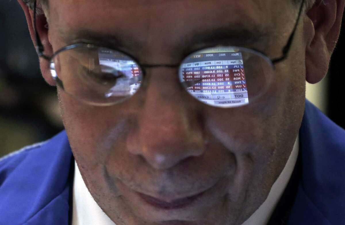 Trader Sal Suarino's glasses reflect the screen of his handheld device as he works on the floor of the New York Stock Exchange. Few market strategists believe that 2014 will be anywhere near as good as 2013.