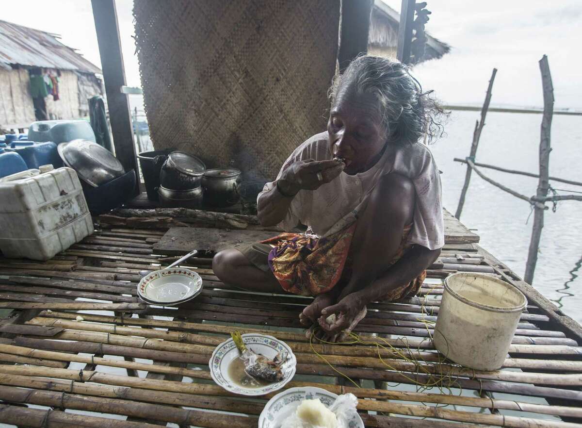 Honna, a Bajau villager, has a fish meal. Carbon dioxide emissions may someday curtail her food supply.