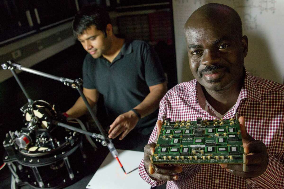 Kwabena Boahen, right, and student Samir Menon demonstrate the use of a biologically inspired processor attached to a robotic arm in a Stanford University laboratory in Palo Alto, Calif.