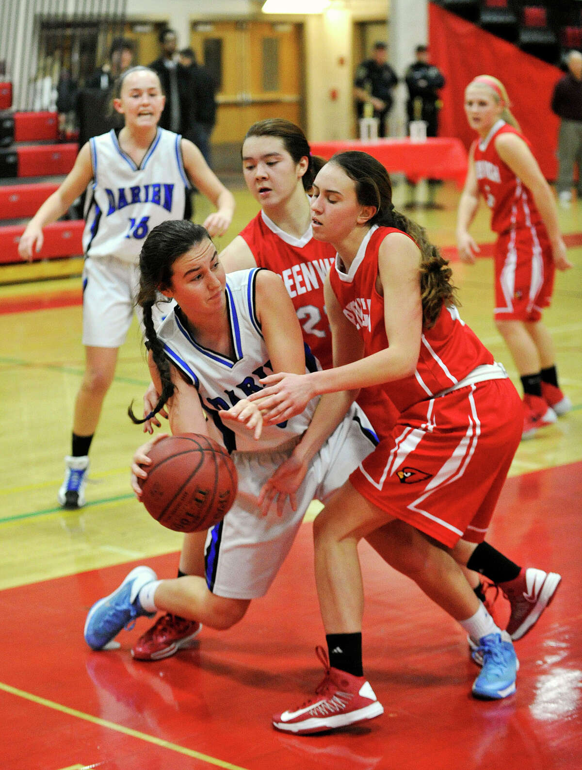 Darien's Kaeleigh Morrill tries to find an open teammate while under pressure from Greenwich's Colleen Bennett, right, and Jamie Kockenmeister during the championship final of the 19th annual Tony LaVista Basketball Tournament at New Canaan High School in New Canaan, Conn., on Monday, Dec. 30, 2013. Greenwich won 66-36.