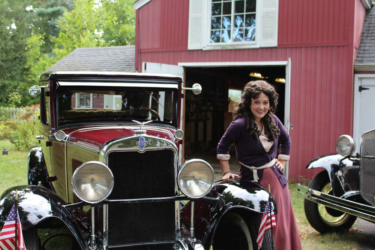 Kristina Thompson, who played Mabel Normand in Rudy Cecera's short fiolm, poses with one of Ron Heinbaugh's cars in his back yard. The cars were featured in Cecera's film.