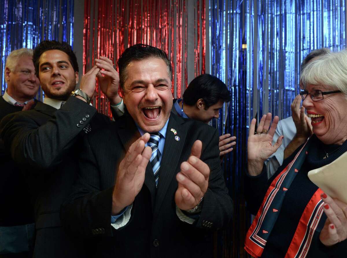 Republican David Cassetti, with his son Anthony left, a newly elected Alderman, and newly elected treasurer Judy Larkin Nicolari, right, celebrates his win over incumbent Mayor James Della Volpe Tuesday, Nov. 5, 2013 at Republican Headquarters in Ansonia, Conn.