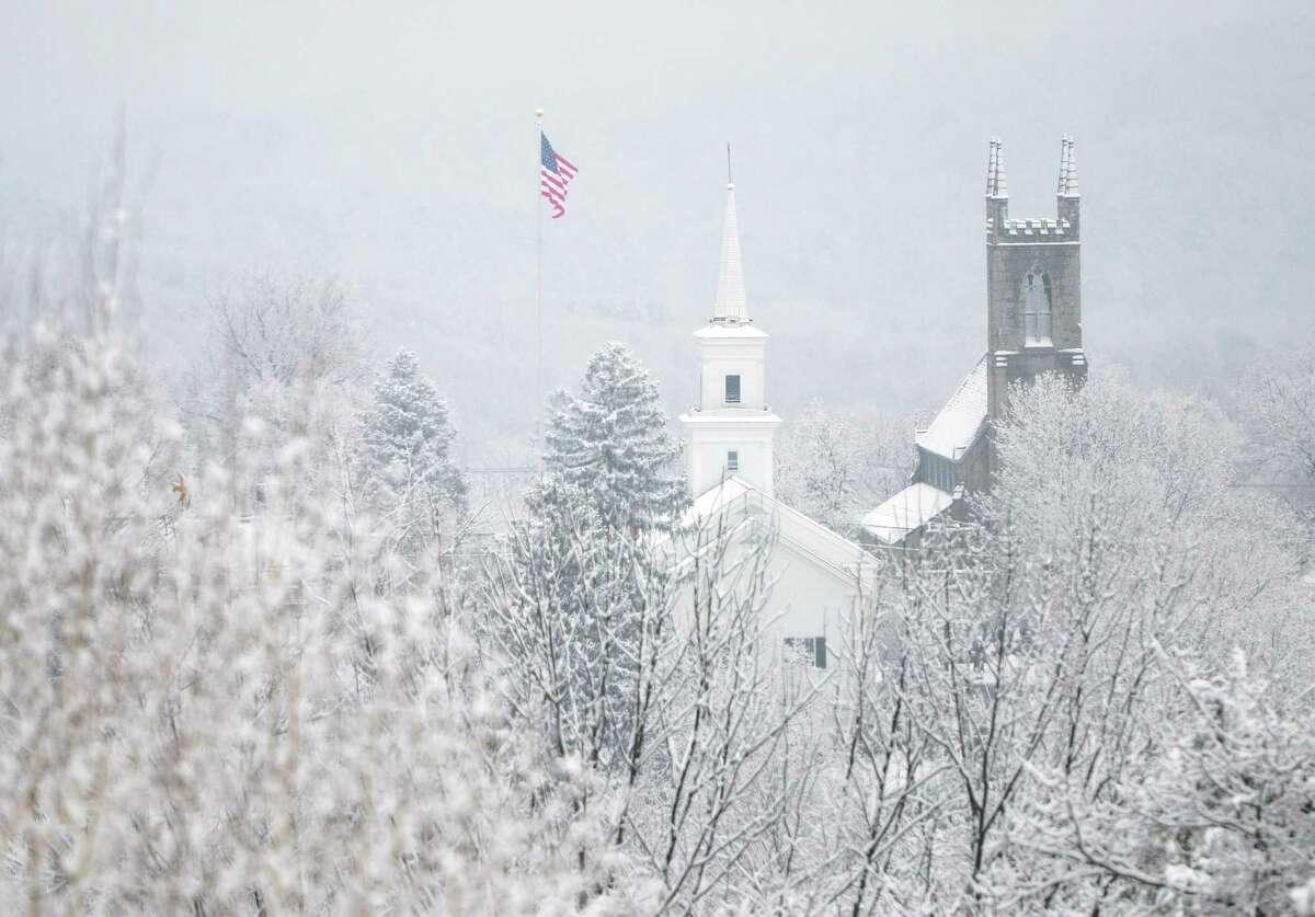 Snow falls over Newtown at the flagpole, Newtown Congregational Church, center, and Trinity Episcopal Church on Tuesday, Dec. 10, 2013. Wednesday's forecast is expected to be in the low 30s and mostly sunny.