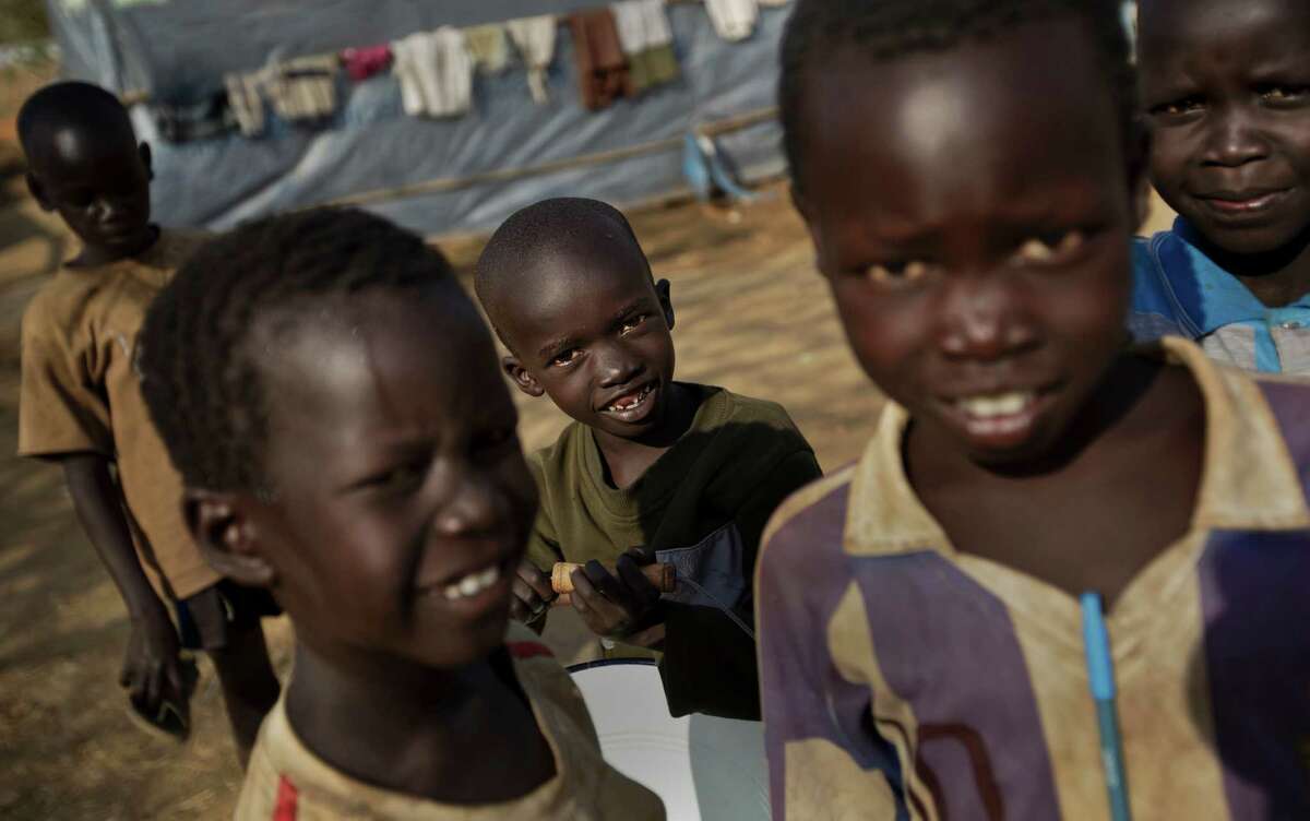 Young displaced boys play at a United Nations compound which has become home to thousands of people displaced by the recent fighting, in the Jebel area on the outskirts of Juba, South Sudan Tuesday, Dec. 31, 2013. Anti-government rebels took control of nearly all of the strategic city of Bor on Tuesday even as officials announced that representatives from the government and the rebels had agreed to hold talks for the first time. (AP Photo/Ben Curtis)