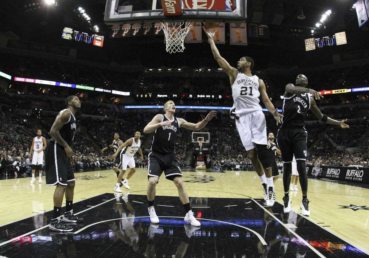 Tim Duncan (21) lays in the ball as Kevin Garnett watches. Garnett failed to make a field goal for the first time since 1996.